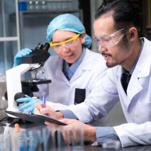 Woman and man with clipboard at microscope